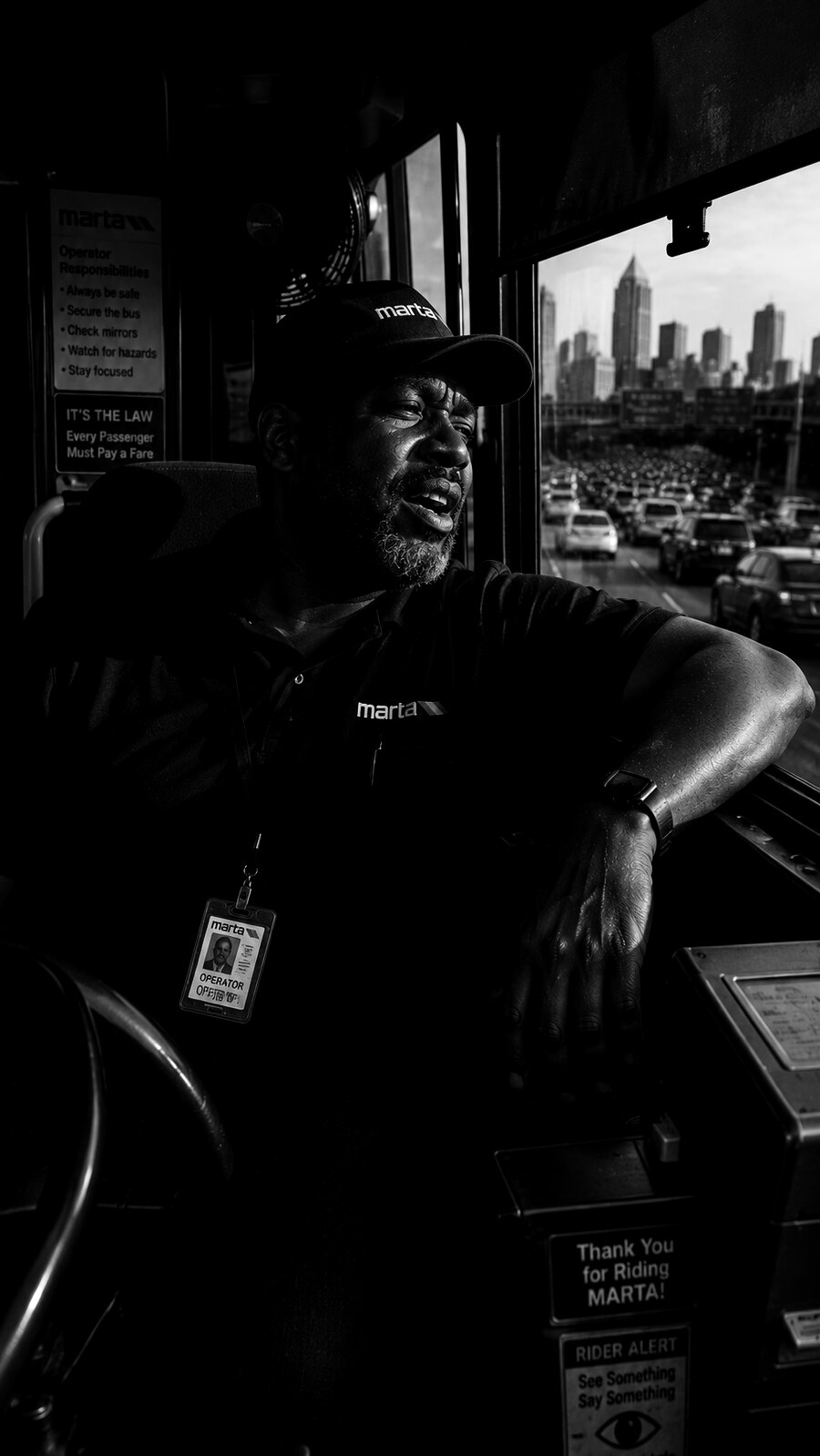 MARTA bus operator behind the wheel with Atlanta skyline in view